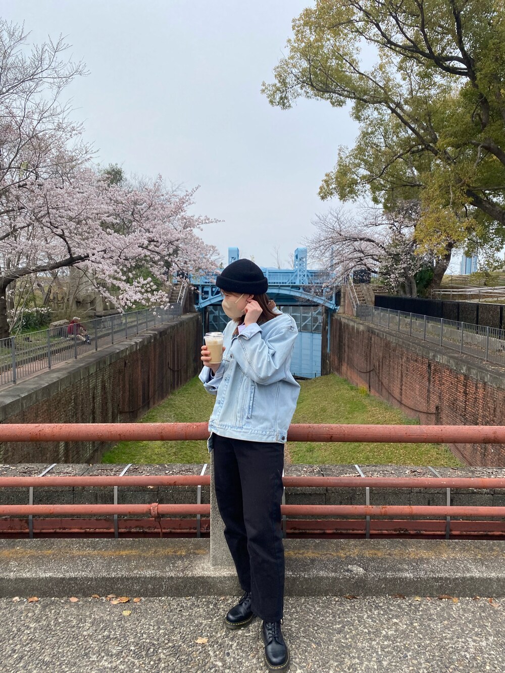 ブルー系のデニムジャケット、ホワイト系のTシャツ/カットソー、ブラック系のブーツを着用したレディースの春コーディネートの2枚目の写真