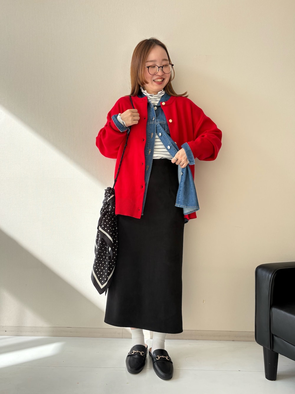 ブラック系のスカート、レッド系のカーディガン/ボレロ、ホワイト系のTシャツ/カットソーを着用したレディースの秋コーディネートの2枚目の写真