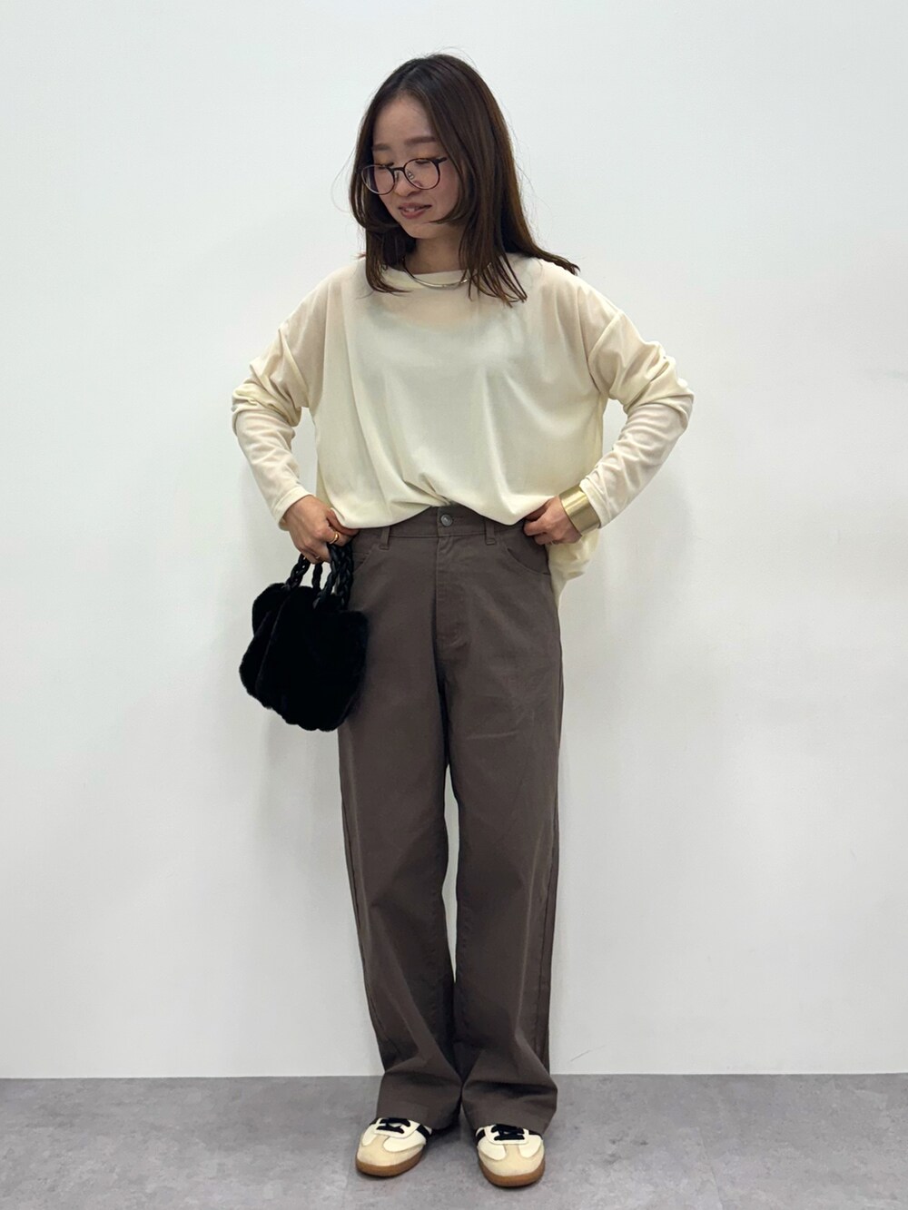 グレー系のパンツ、ベージュ系のTシャツ/カットソーを着用したレディースの秋コーディネートの2枚目の写真