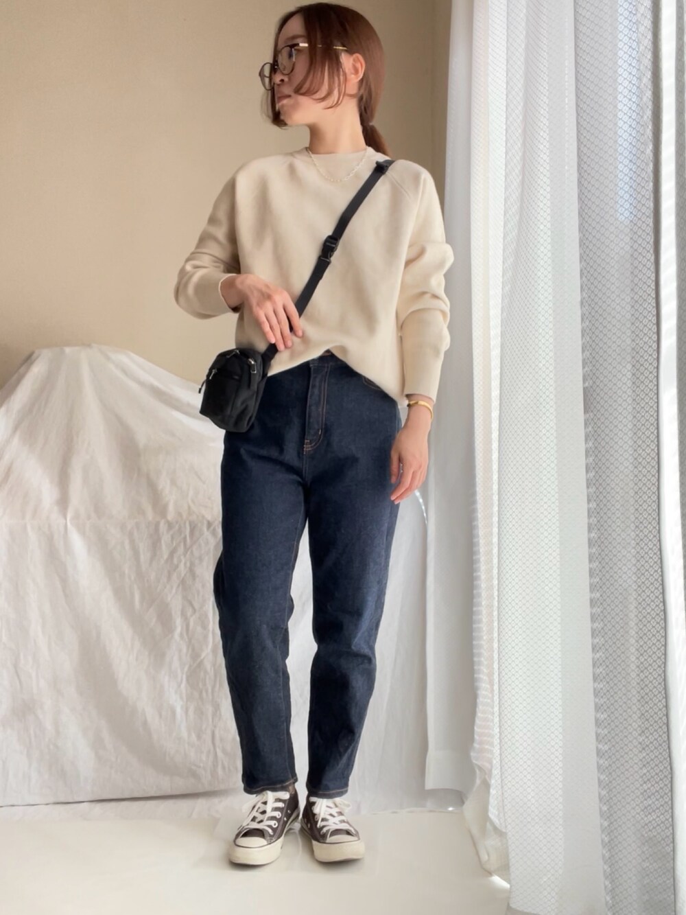 ベージュ系のニット/セーター、ブルー系のデニムパンツ、ベージュ系のニット/セーターを着用したレディースの秋コーディネートの3枚目の写真