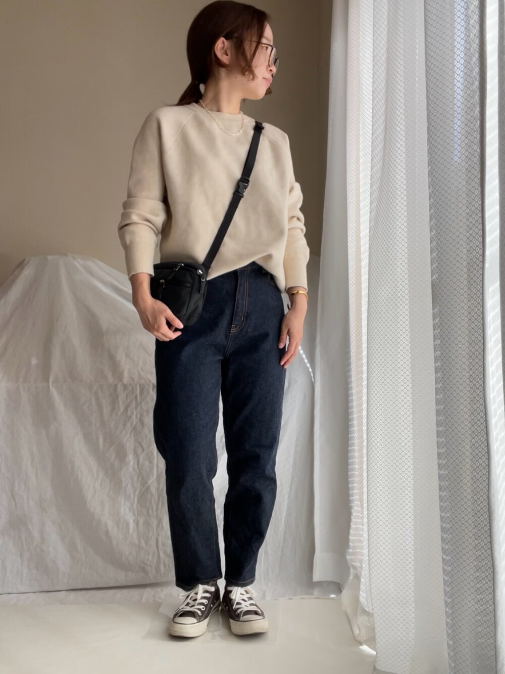 ベージュ系のニット/セーター、ブルー系のデニムパンツ、ベージュ系のニット/セーターを着用したレディースの秋コーディネートの2枚目の写真