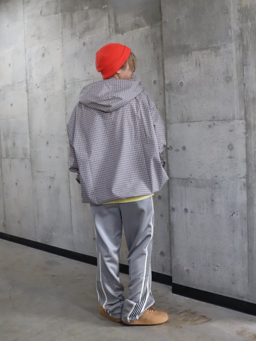 グレー系のスラックス、イエロー系のTシャツ/カットソー、オレンジ系のニットキャップ/ビーニーを着用したレディースの春コーディネートの4枚目の写真