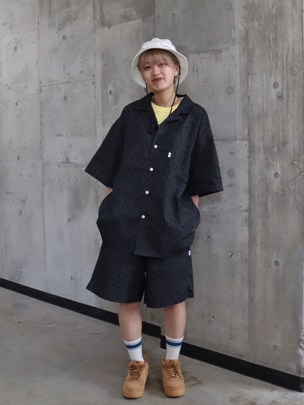 イエロー系のTシャツ/カットソー、ブラック系のシャツ/ブラウス、ブラック系のカーゴパンツを着用したレディースの春コーディネートの2枚目の写真