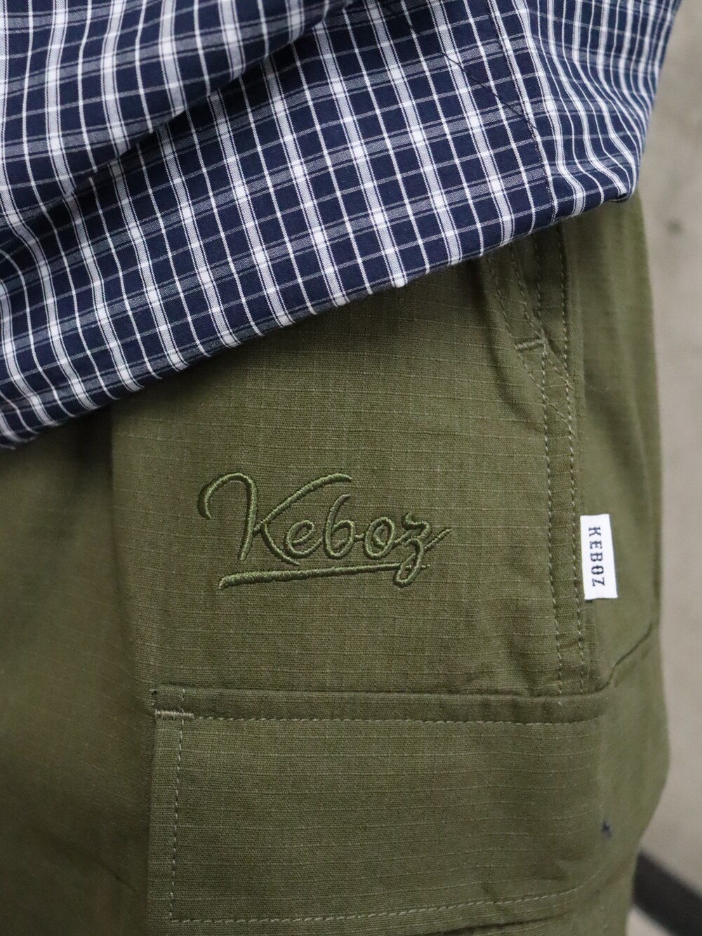 グリーン系のカーゴパンツ、ホワイト系のジャケット/アウター、ブルー系のシャツ/ブラウスを着用したレディースの春コーディネートの5枚目の写真