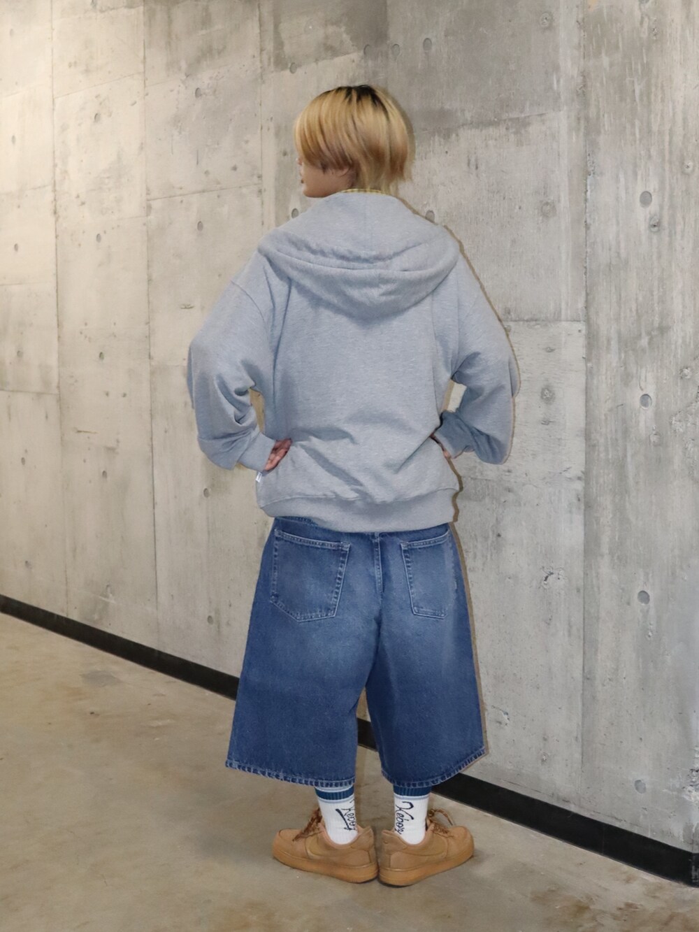 ブルー系のデニムパンツ、イエロー系のシャツ/ブラウス、グレー系のトップスを着用したレディースの春コーディネートの3枚目の写真