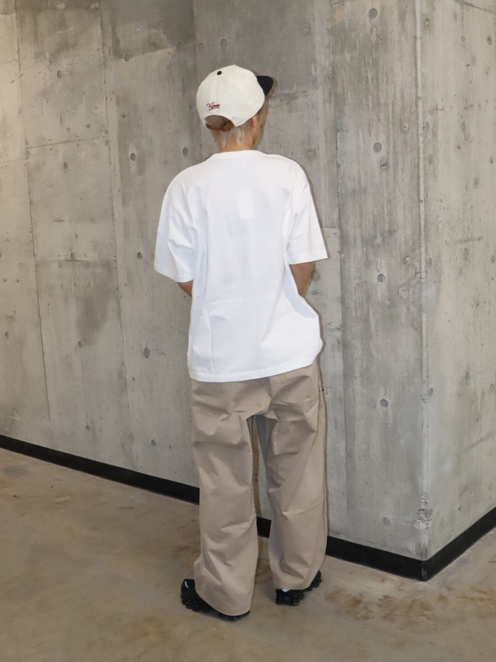 ベージュ系のカーゴパンツ、ホワイト系のキャップを着用したレディースの春コーディネートの2枚目の写真