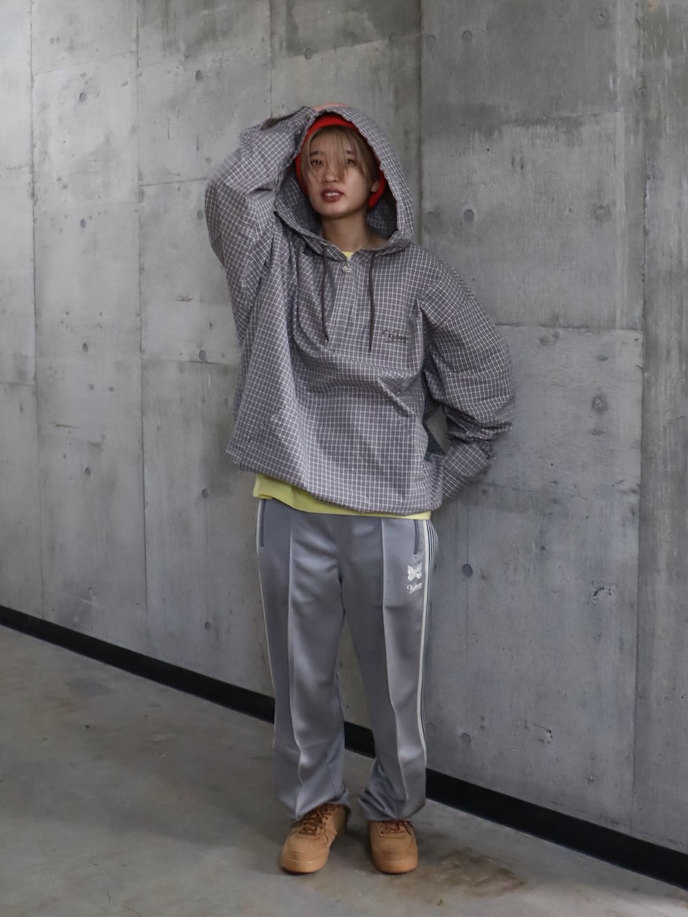 グレー系のスラックス、イエロー系のTシャツ/カットソー、オレンジ系のニットキャップ/ビーニーを着用したレディースの春コーディネートの3枚目の写真