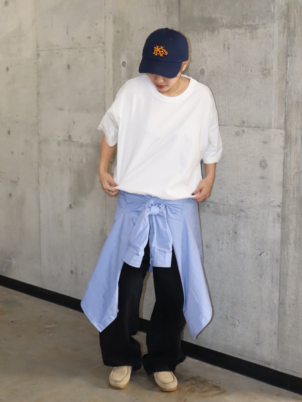 ホワイト系のTシャツ/カットソー、ブラック系のデニムパンツ、ブルー系のキャップを着用したレディースの春コーディネートの3枚目の写真