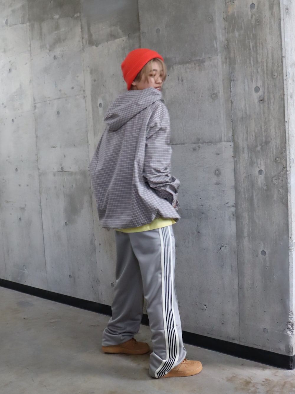 グレー系のスラックス、イエロー系のTシャツ/カットソー、オレンジ系のニットキャップ/ビーニーを着用したレディースの春コーディネートの2枚目の写真