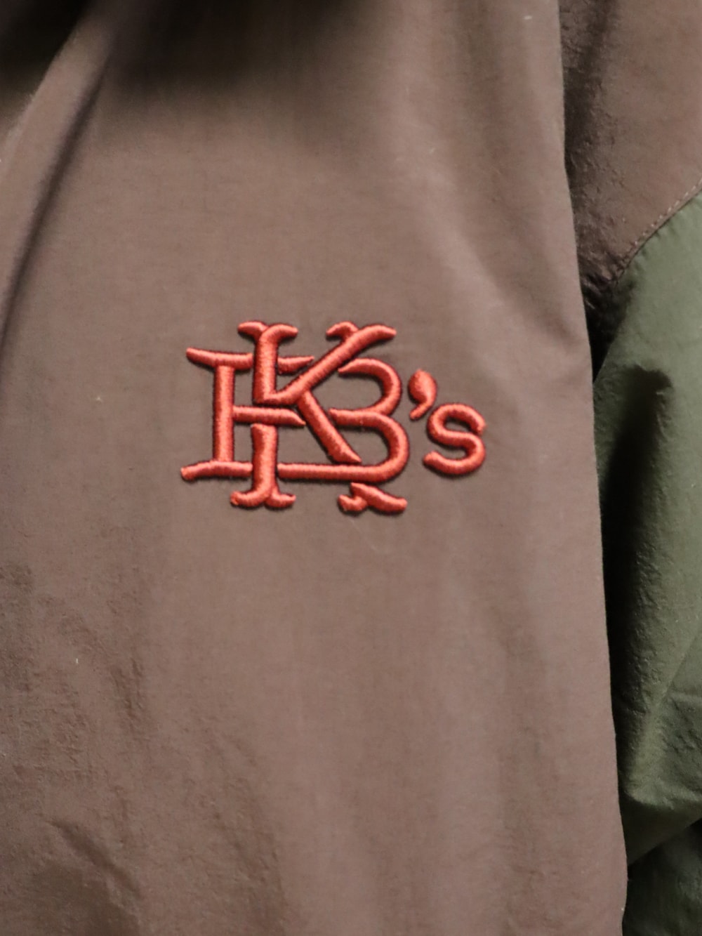 イエロー系のパーカー、イエロー系のスウェットパンツ、ブラウン系のナイロンジャケットを着用したレディースの春コーディネートの4枚目の写真