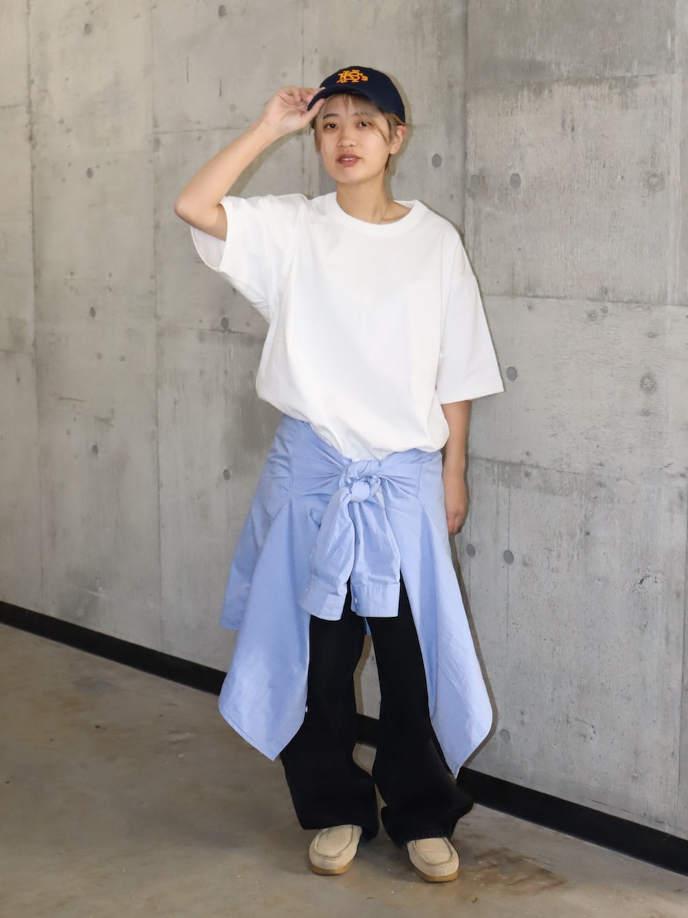 ホワイト系のTシャツ/カットソー、ブラック系のデニムパンツ、ブルー系のキャップを着用したレディースの春コーディネートの2枚目の写真