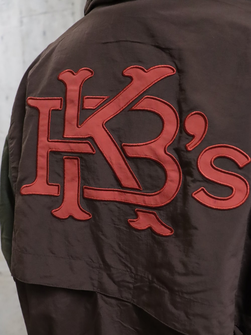 イエロー系のパーカー、イエロー系のスウェットパンツ、ブラウン系のナイロンジャケットを着用したレディースの春コーディネートの5枚目の写真