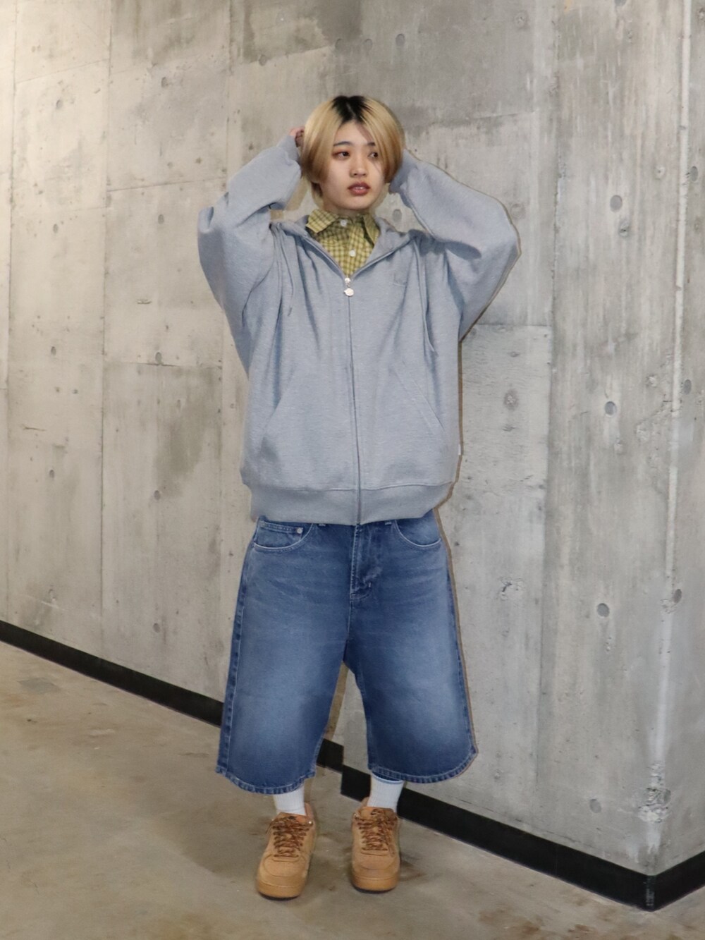 ブルー系のデニムパンツ、イエロー系のシャツ/ブラウス、グレー系のトップスを着用したレディースの春コーディネートの2枚目の写真