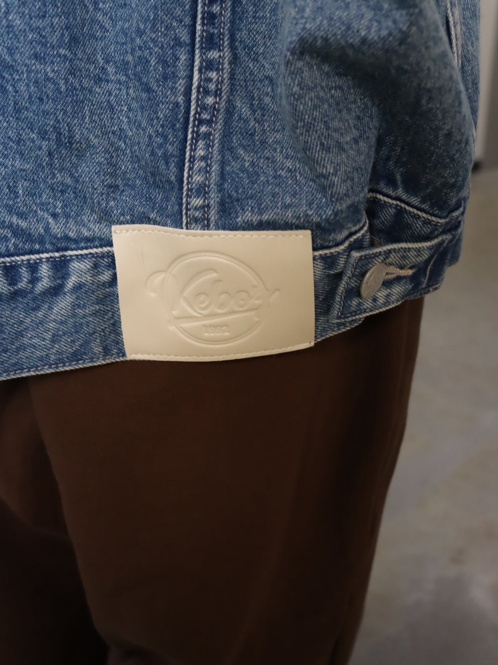 ブルー系のデニムジャケット、ブラック系のTシャツ/カットソー、ブラウン系のスウェットパンツを着用したレディースの春コーディネートの3枚目の写真