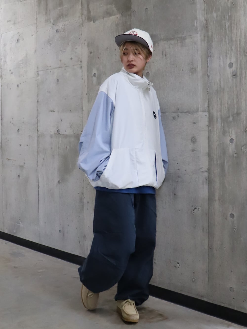 ホワイト系のナイロンジャケット、ブルー系のTシャツ/カットソー、ブルー系のパンツを着用したレディースの春コーディネートの2枚目の写真