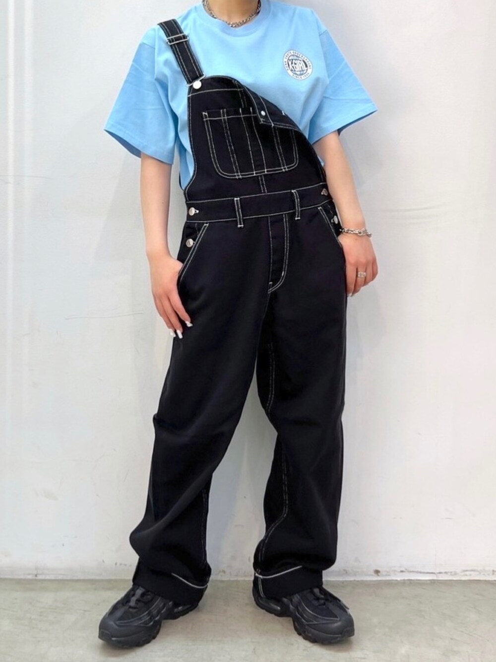 ブルー系のTシャツ/カットソー、ブラック系のサロペット/オーバーオール、シルバー系のネックレスを着用したレディースの春コーディネートの3枚目の写真