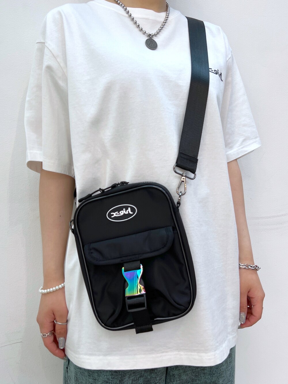 ブラック系のショルダーバッグ、ホワイト系のTシャツ/カットソー、グリーン系のスウェットパンツを着用したレディースの夏コーディネートの4枚目の写真