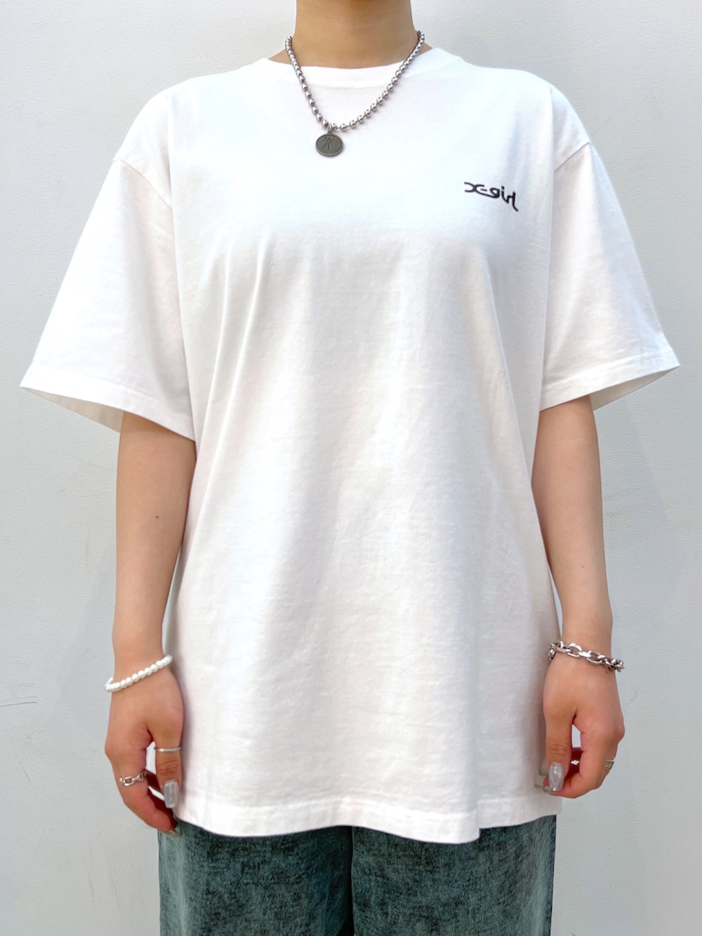 ブラック系のショルダーバッグ、ホワイト系のTシャツ/カットソー、グリーン系のスウェットパンツを着用したレディースの夏コーディネートの3枚目の写真