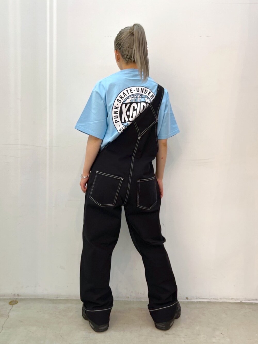 ブルー系のTシャツ/カットソー、ブラック系のサロペット/オーバーオール、シルバー系のネックレスを着用したレディースの春コーディネートの2枚目の写真
