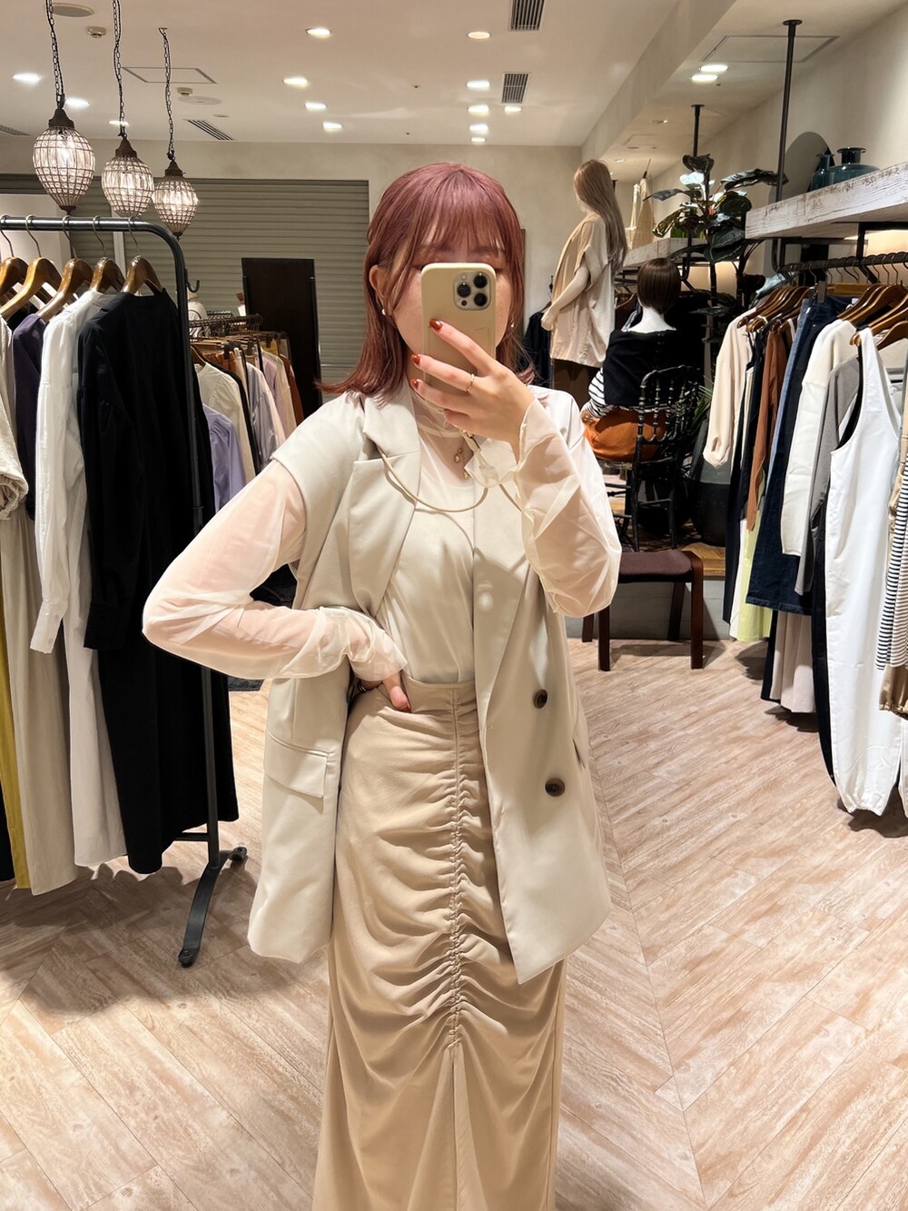 ホワイト系のブーツ、ベージュ系のスカート、ホワイト系のベストを着用したレディースの秋コーディネートの2枚目の写真