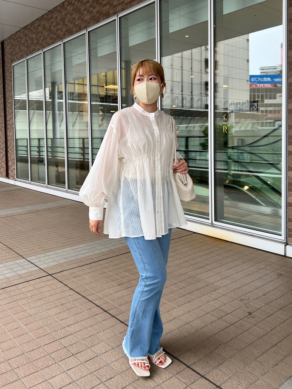 ホワイト系のシャツ/ブラウス、ホワイト系のトートバッグ、ブルー系のデニムパンツを着用したレディースの夏コーディネートの2枚目の写真