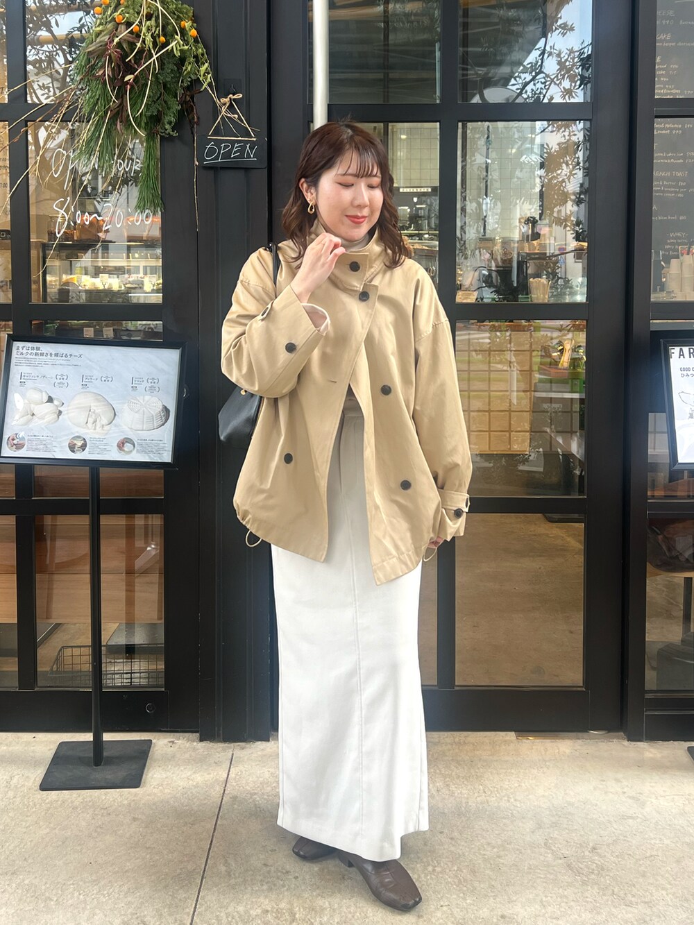 ホワイト系のスカート、ベージュ系のその他アウター、ブラック系のショルダーバッグを着用したレディースの冬コーディネートの4枚目の写真