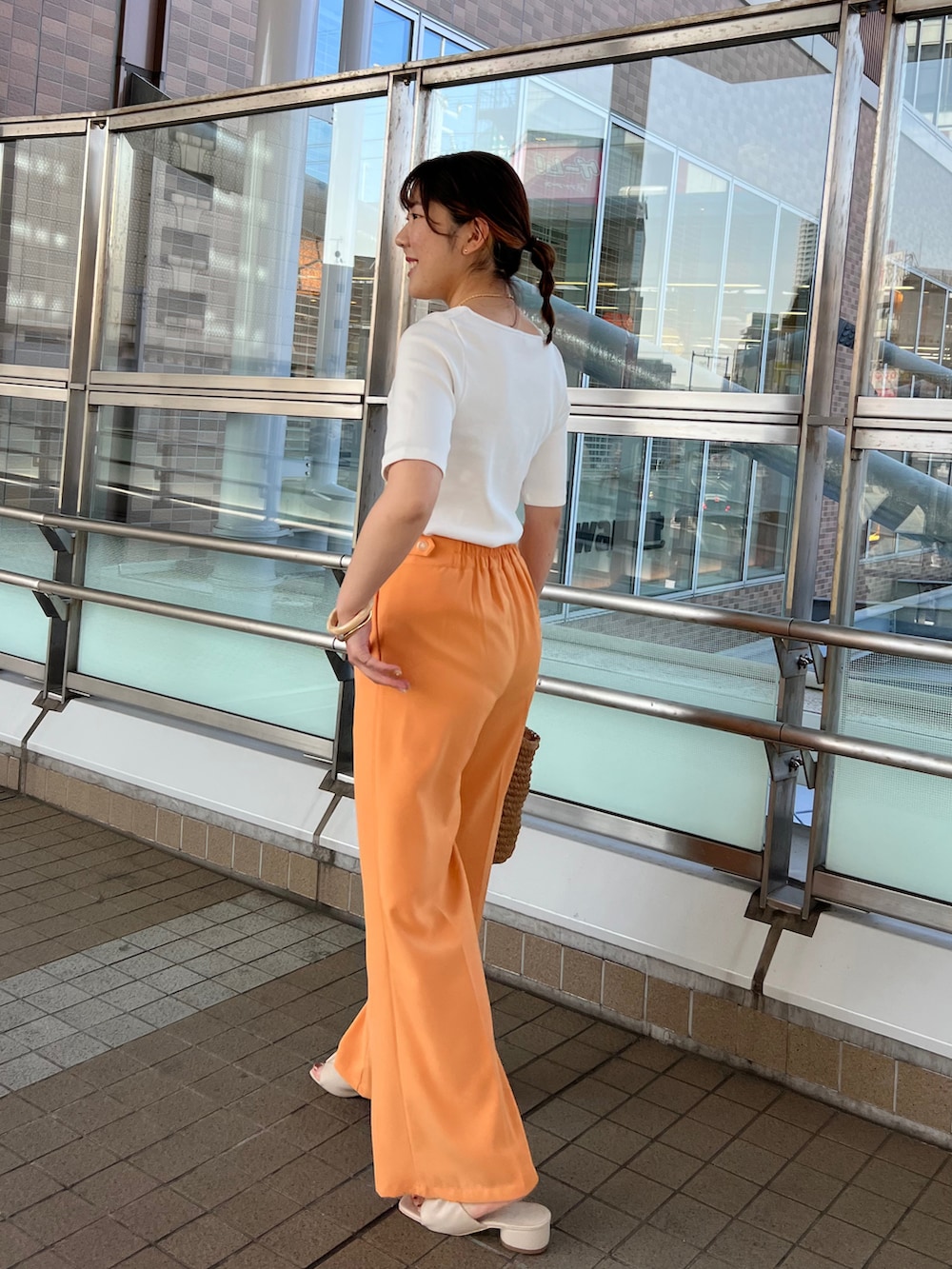 ホワイト系のサンダル、オレンジ系のハンドバッグ、オレンジ系のその他パンツを着用したレディースの春コーディネートの3枚目の写真
