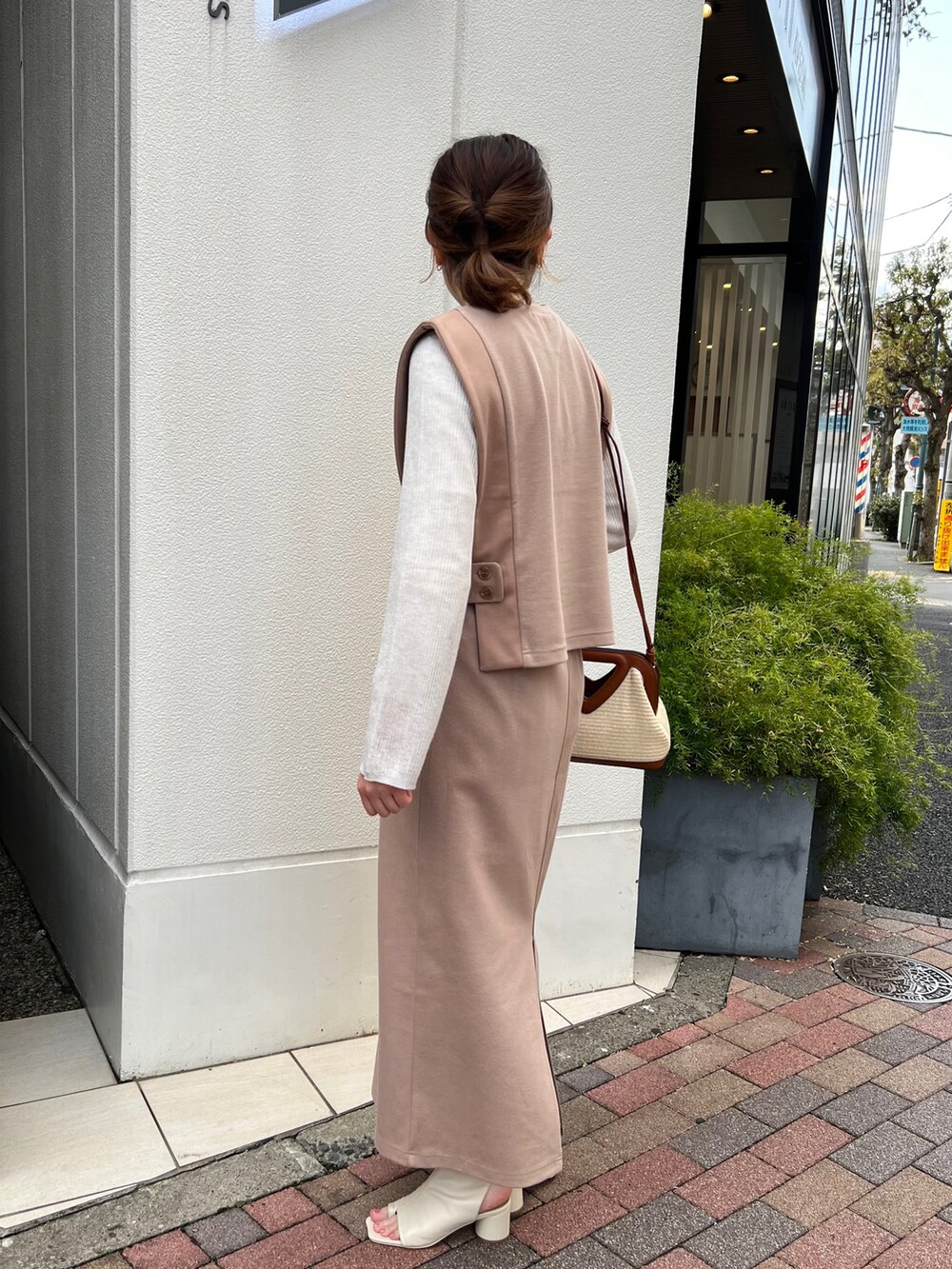 ブラック系のその他シューズ、ベージュ系のベスト、ベージュ系のスカートを着用したレディースの春コーディネートの2枚目の写真