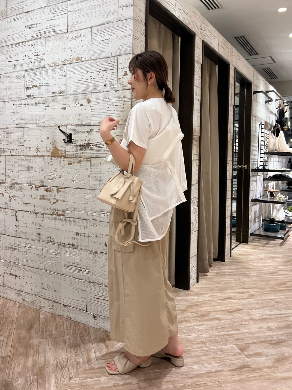 ベージュ系のスカート、ホワイト系のTシャツ/カットソー、ベージュ系のハンドバッグを着用したレディースの夏コーディネートの3枚目の写真