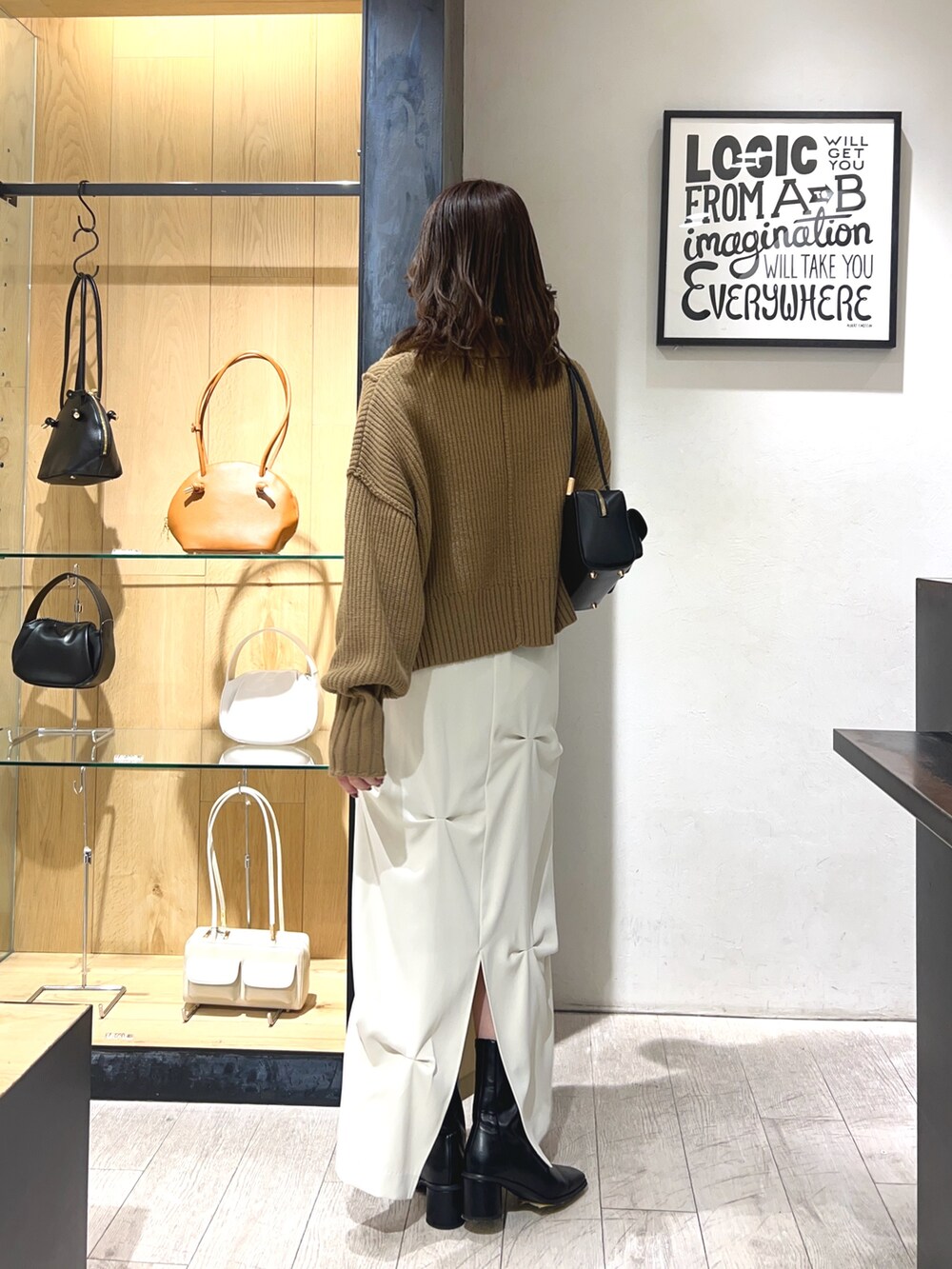 ベージュ系のカーディガン/ボレロ、ホワイト系のスカート、ブラック系のショルダーバッグを着用したレディースの冬コーディネートの3枚目の写真