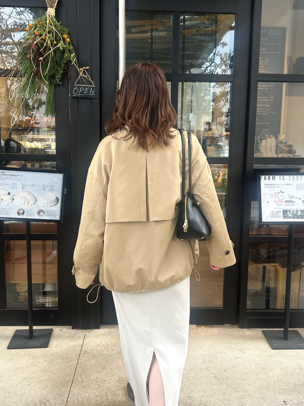 ホワイト系のスカート、ベージュ系のその他アウター、ブラック系のショルダーバッグを着用したレディースの冬コーディネートの3枚目の写真