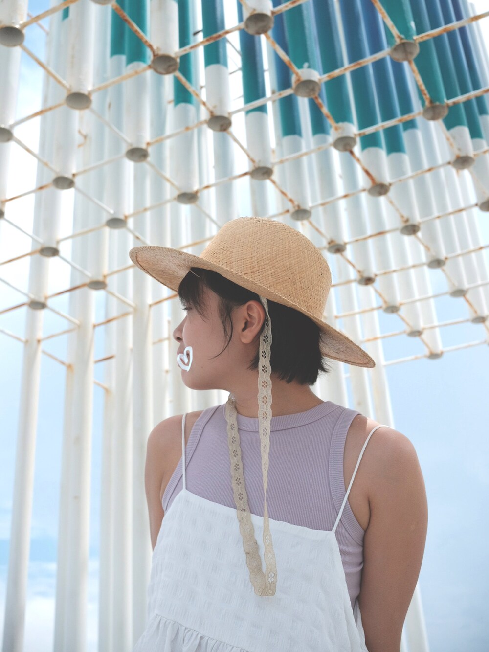 ホワイト系のジャンパースカート、ホワイト系のサンダルを着用したレディースの夏コーディネートの2枚目の写真