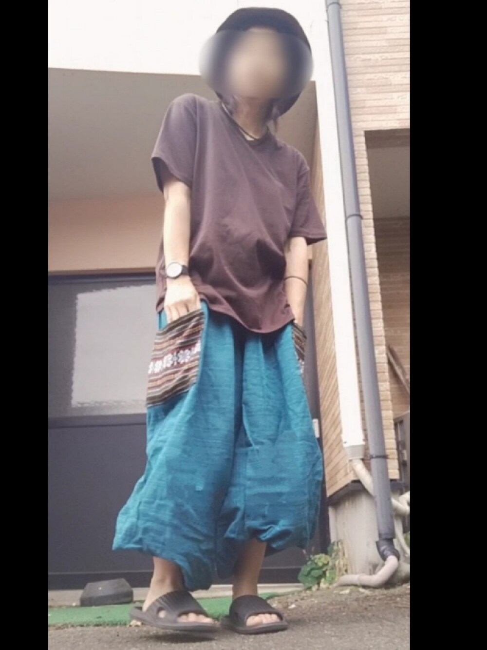 グリーン系のパンツを着用したレディースの夏コーディネートの2枚目の写真