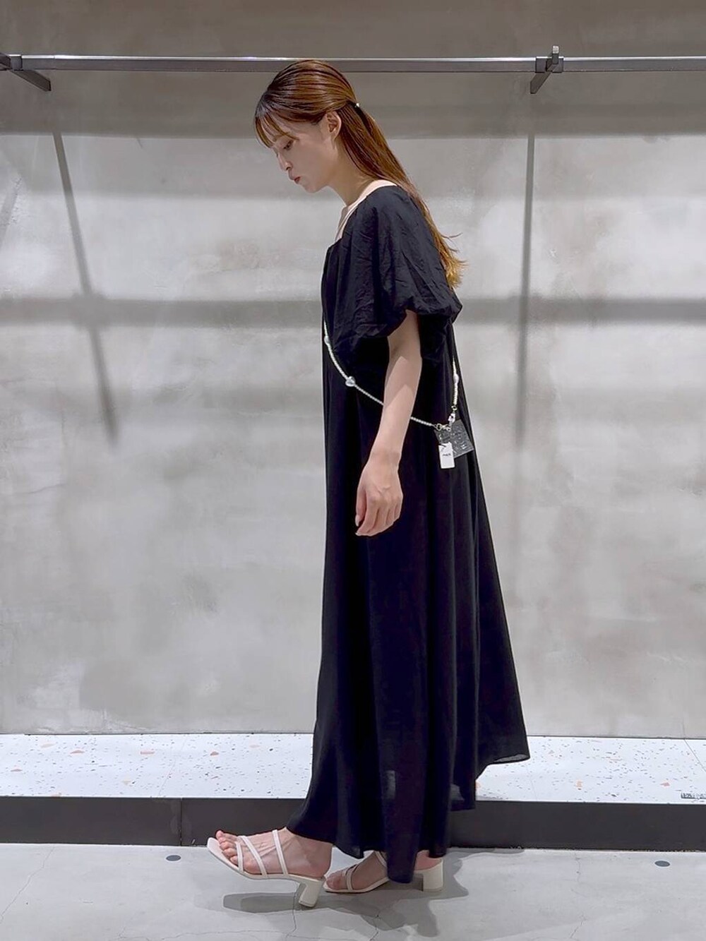 ベージュ系のキャミソール、ホワイト系のサンダル、ブラック系のワンピースを着用したレディースの夏コーディネートの4枚目の写真