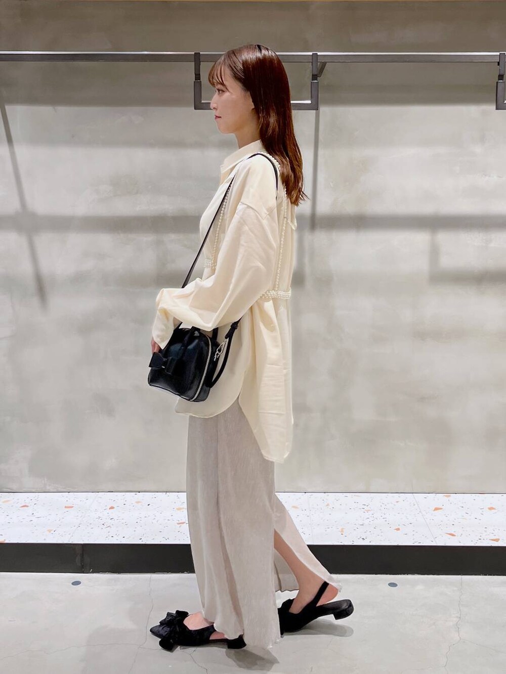 ブラック系のパンプス、ホワイト系のスカート、ブラック系のボストンバッグを着用したレディースの秋コーディネートの4枚目の写真