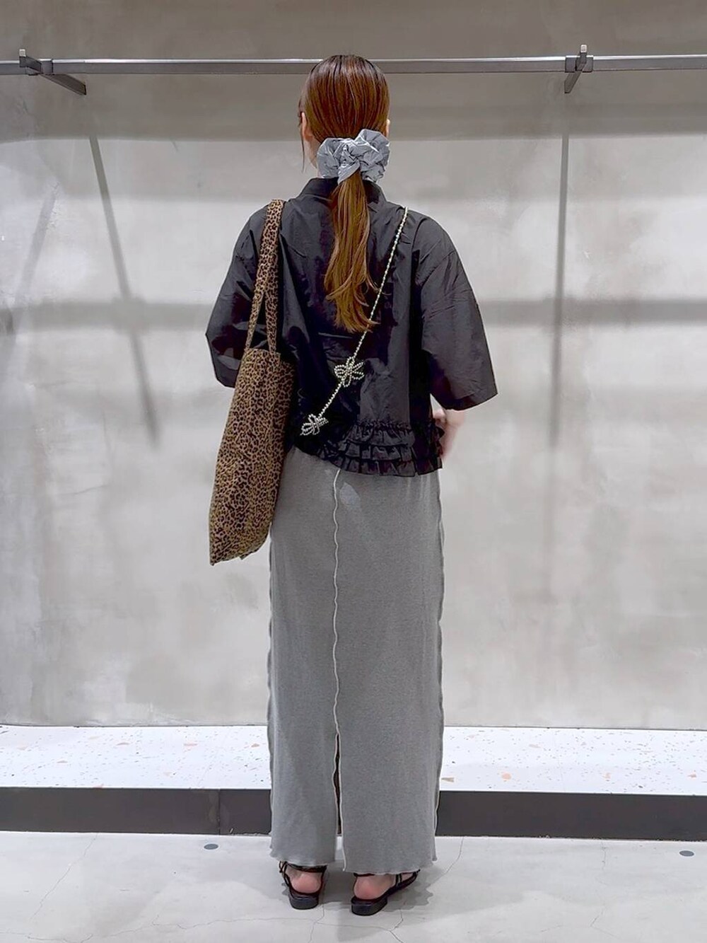 その他のトートバッグ、ブラック系のサンダル、グレー系のスカートを着用したレディースの夏コーディネートの6枚目の写真