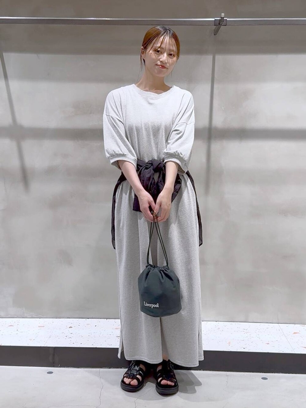 ブラック系のサンダル、ブラック系のシャツ/ブラウス、グリーン系のショルダーバッグを着用したレディースの夏コーディネートの3枚目の写真