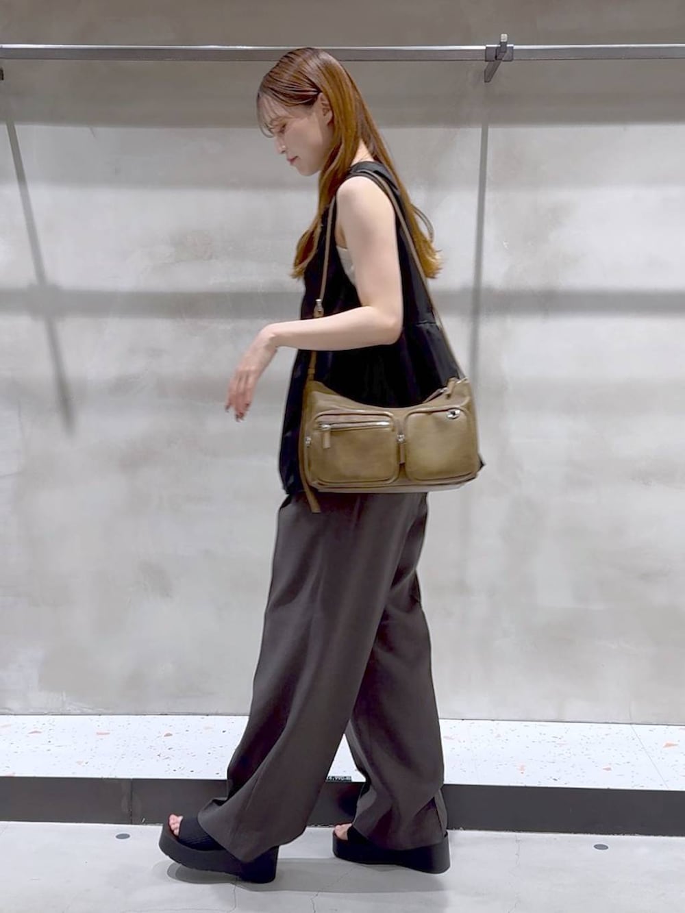 ブラック系のサンダル、ホワイト系のキャミソール、グレー系のスラックスを着用したレディースの夏コーディネートの4枚目の写真