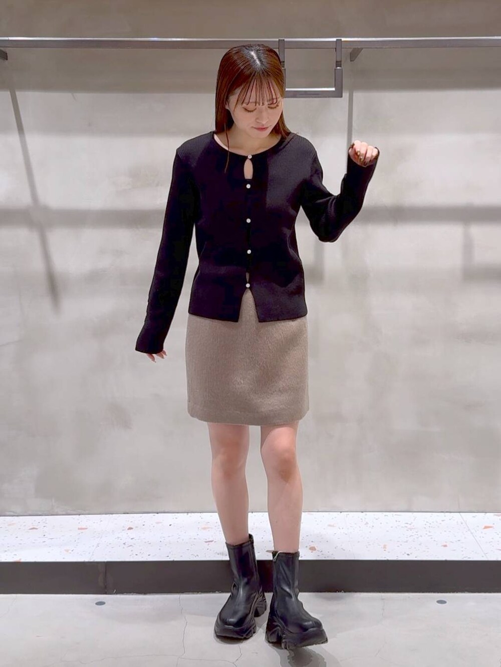 ブラック系のブーツ、ブラック系のトートバッグ、ベージュ系のその他アウターを着用したレディースの冬コーディネートの2枚目の写真