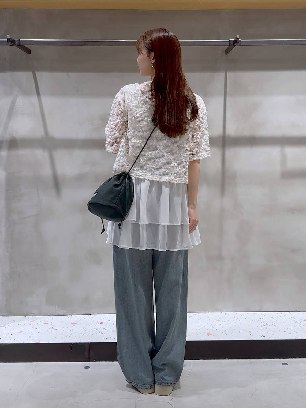 ブルー系のデニムパンツ、ホワイト系のサンダル、ホワイト系のタンクトップを着用したレディースの夏コーディネートの4枚目の写真