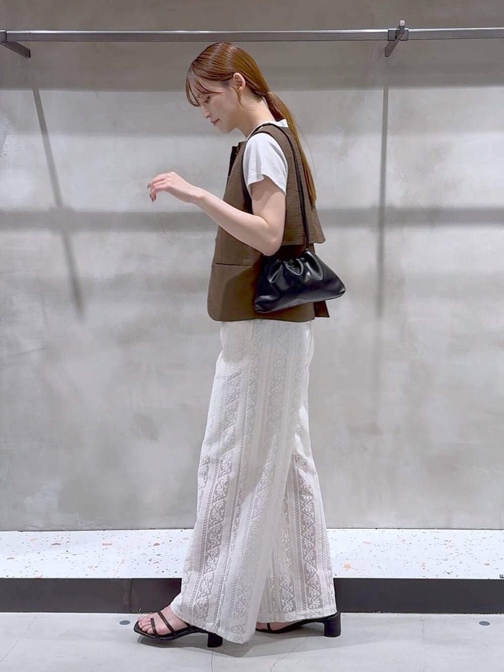 ブラウン系のブルゾン、ホワイト系のその他パンツ、ブラック系のサンダルを着用したレディースの夏コーディネートの4枚目の写真