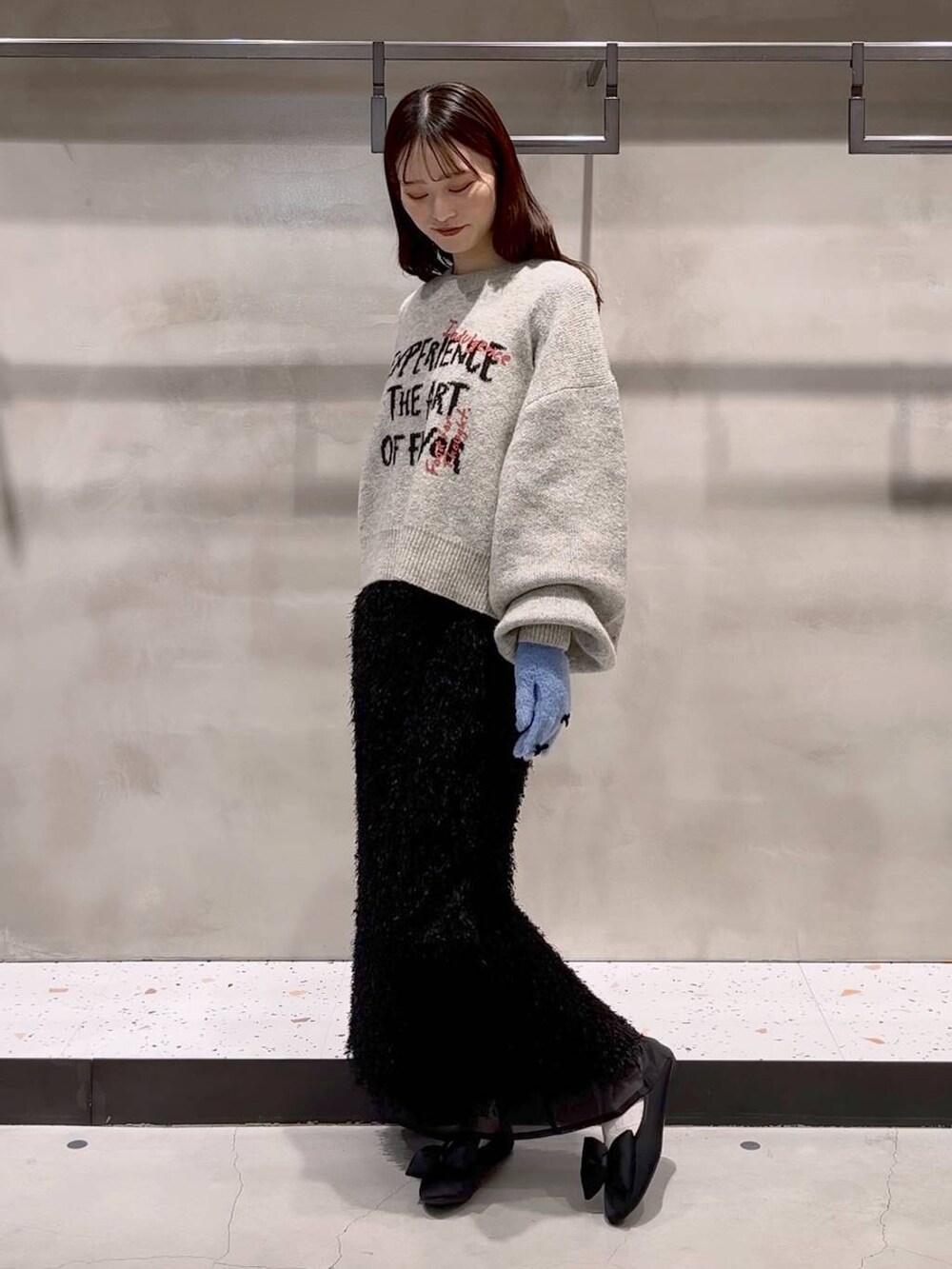 ブラック系のバレエシューズ、グレー系のニット/セーター、ブラック系のスカートを着用したレディースの秋コーディネートの5枚目の写真