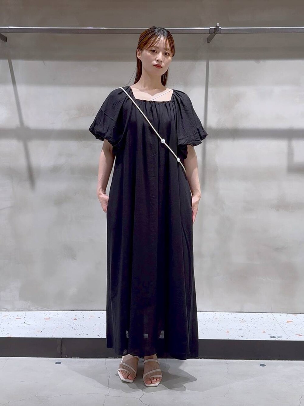 ベージュ系のキャミソール、ホワイト系のサンダル、ブラック系のワンピースを着用したレディースの夏コーディネートの3枚目の写真