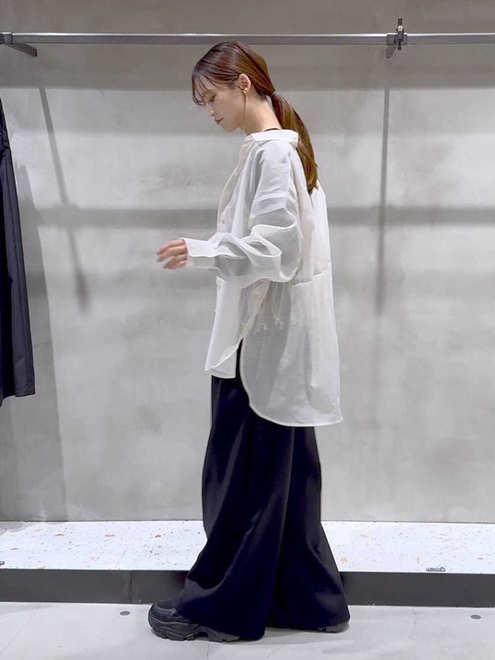 ベージュ系のベスト、ホワイト系のシャツ/ブラウス、ブラック系のスニーカーを着用したレディースの春コーディネートの4枚目の写真