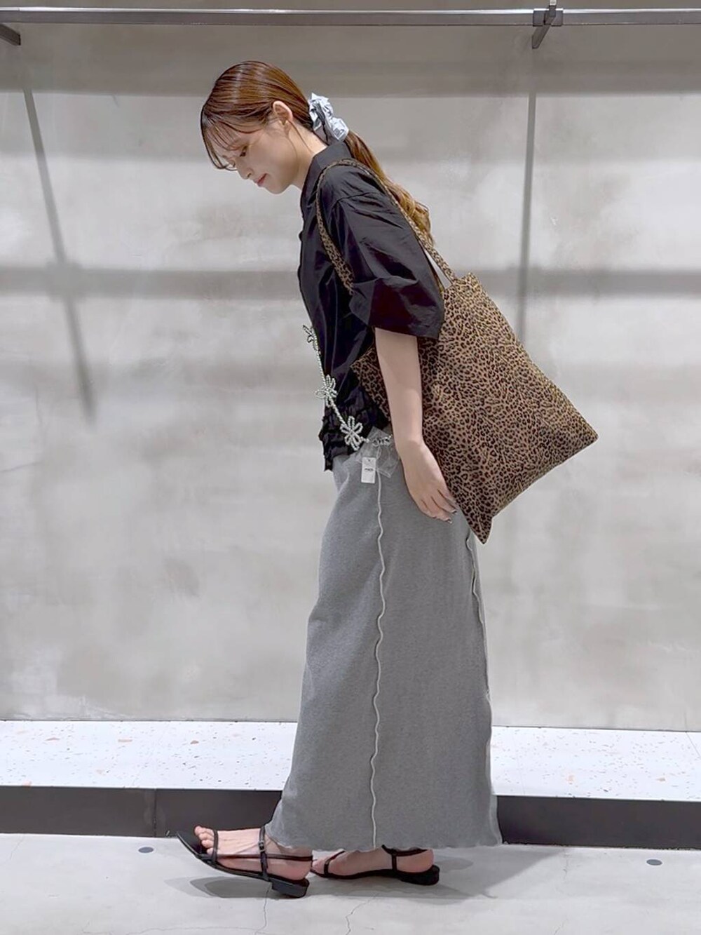 その他のトートバッグ、ブラック系のサンダル、グレー系のスカートを着用したレディースの夏コーディネートの4枚目の写真