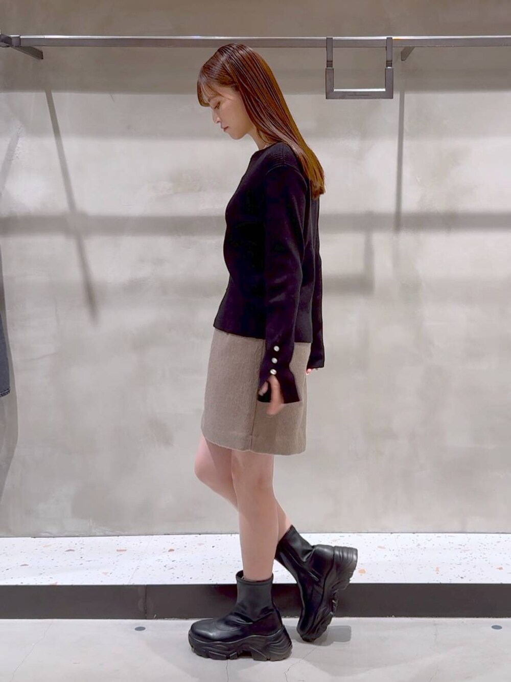 ブラック系のブーツ、ブラック系のトートバッグ、ベージュ系のその他アウターを着用したレディースの冬コーディネートの4枚目の写真