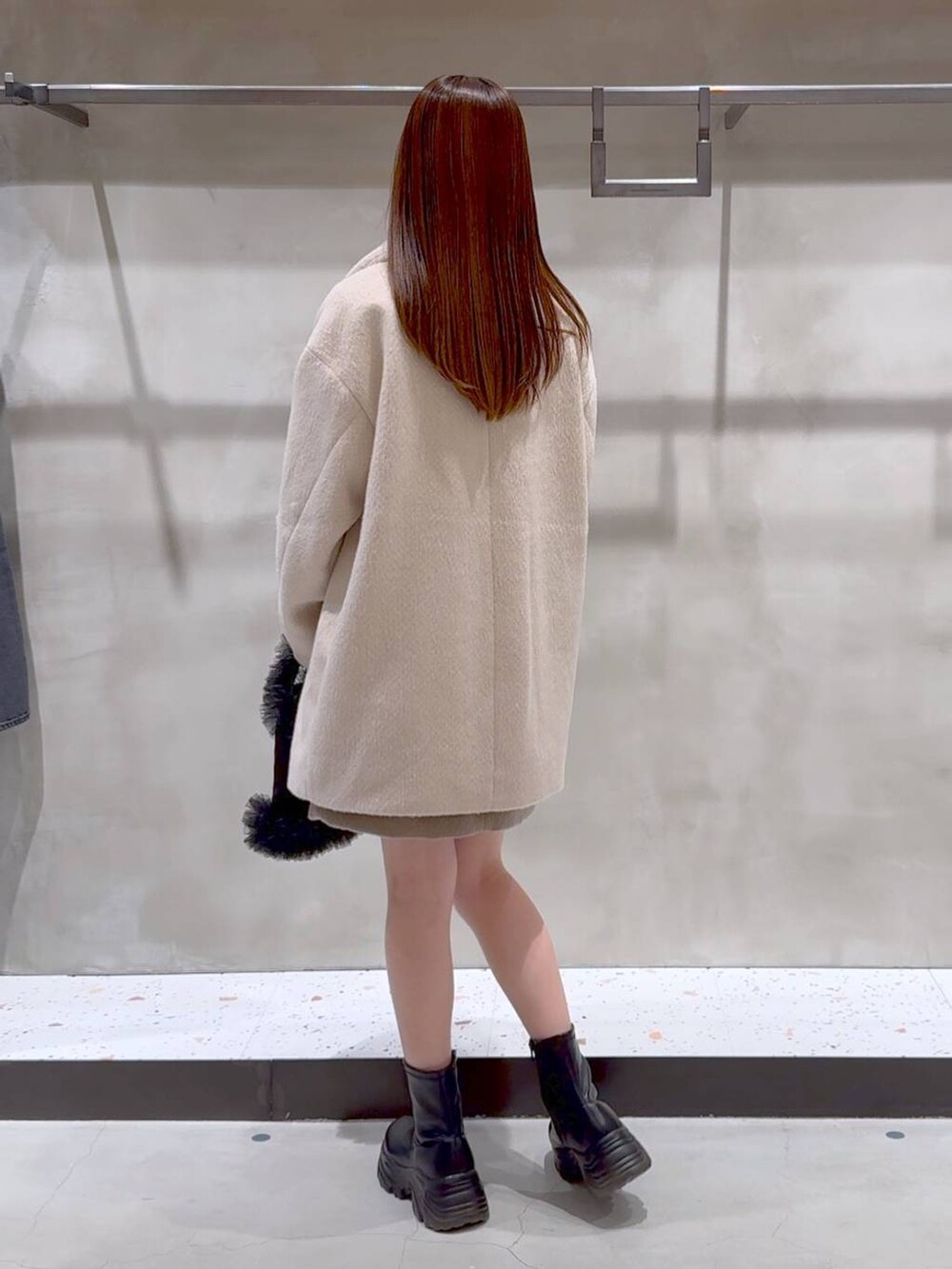 ブラック系のブーツ、ブラック系のトートバッグ、ベージュ系のその他アウターを着用したレディースの冬コーディネートの9枚目の写真