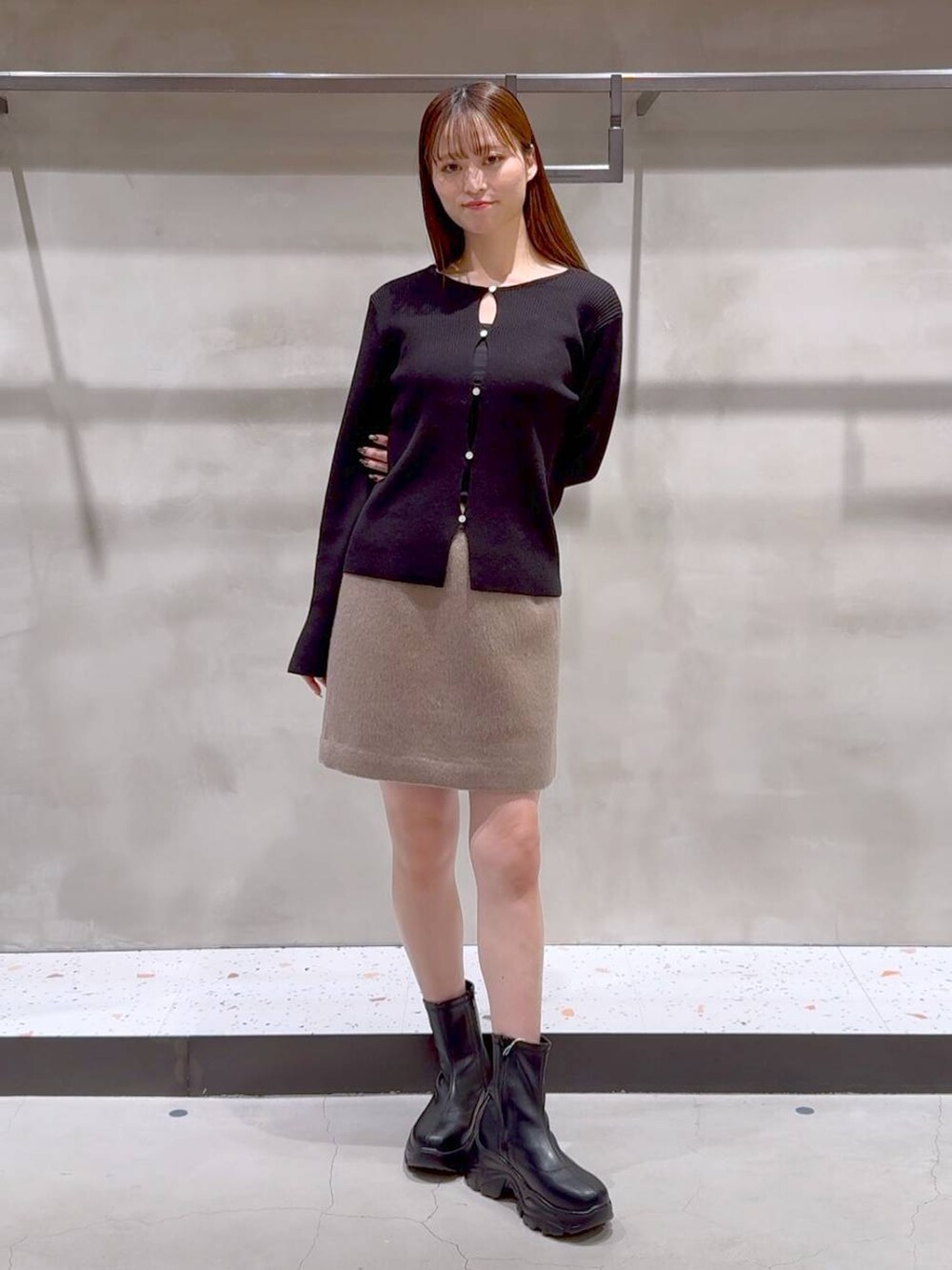 ブラック系のブーツ、ブラック系のトートバッグ、ベージュ系のその他アウターを着用したレディースの冬コーディネートの3枚目の写真