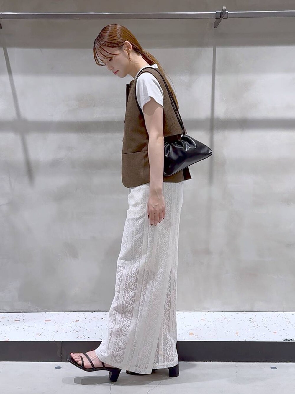 ブラウン系のブルゾン、ホワイト系のその他パンツ、ブラック系のサンダルを着用したレディースの夏コーディネートの5枚目の写真