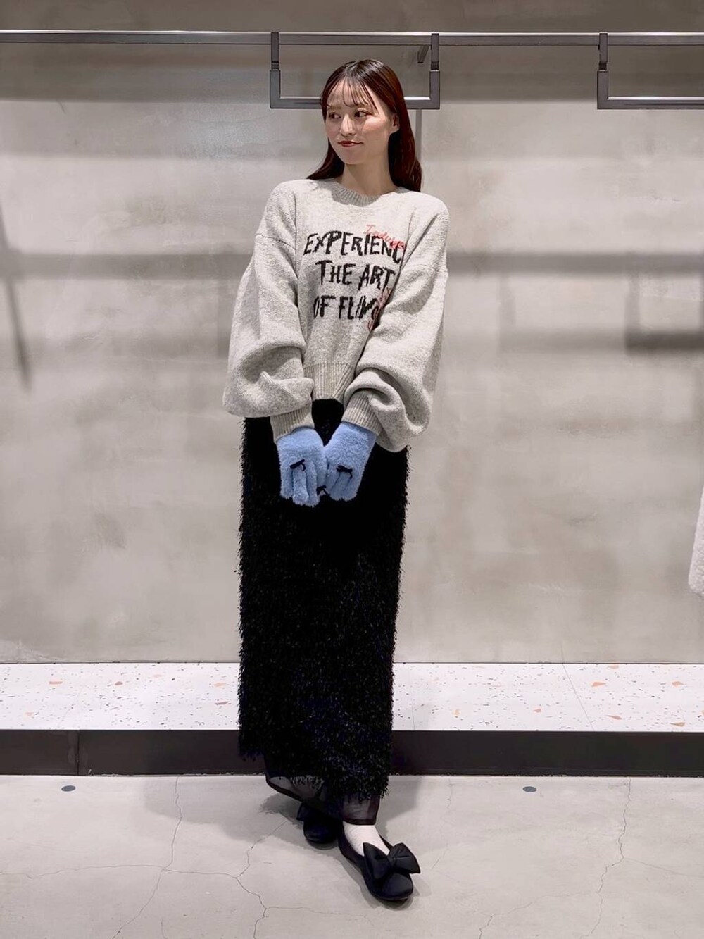 ブラック系のバレエシューズ、グレー系のニット/セーター、ブラック系のスカートを着用したレディースの秋コーディネートの2枚目の写真